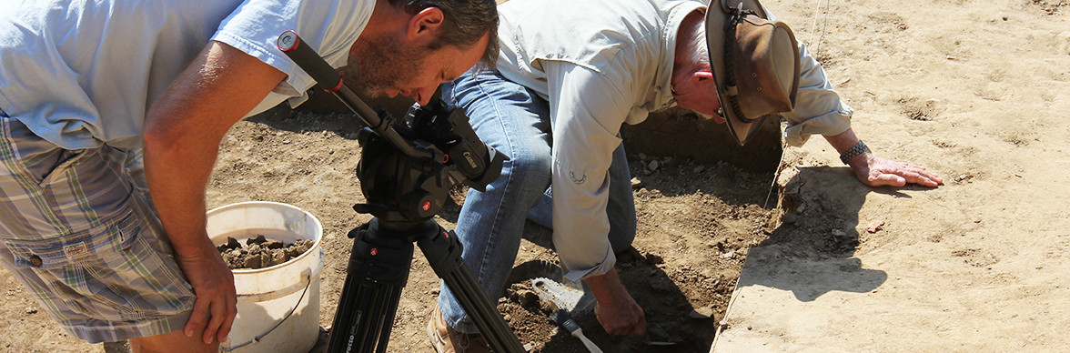 Man films archaeologist excavating