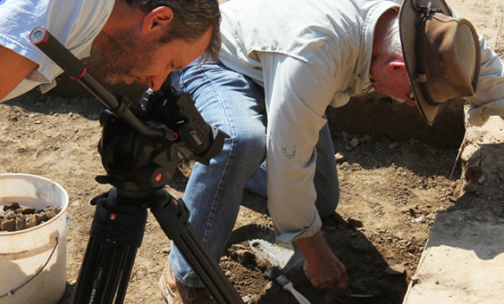 Man films archaeologist excavating