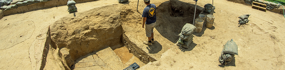 Archaeologist standing on a balk between two excavation units