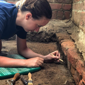 Archaeologist excavating brick foudnations