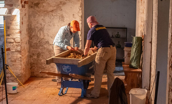 Senior Staff Archaeologist Mary Anna Hartley and Staff Archaeologist Caitlin Delmas screen for artifacts during the excavations in Bacon's Castle cellar.