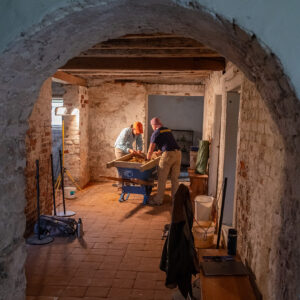 Senior Staff Archaeologist Mary Anna Hartley and Staff Archaeologist Caitlin Delmas screen through soil excavated from Bacon's Castle's cellar.