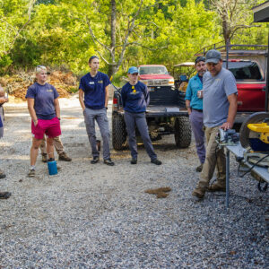 Buildings and Grounds Manager Shane Shortt instructs the archaeological crew on safe operation of power tools prior to their building of the burial structures. Shane recently received his OSHA 30 certification.