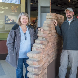 Archaeologists stand inside new museum exhibit