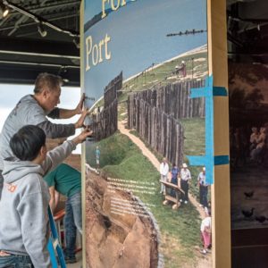 Workers install illustrated museum panel