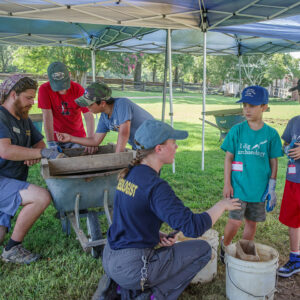 Archaeological Field Technician Josh Barber and Staff Archaeologist Natalie Reid assist some of the campers with screening.