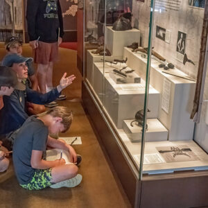 Staff Archaeologist Natalie Reid discusses the Archaearium's Gentleman Soldiers exhibit with campers.