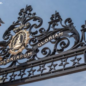 Worker stands on ladder to restore gate topper