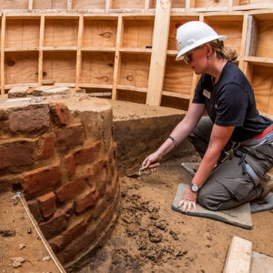 Archaeological Intern Eleanor Robb digging in the well's builder's trench.