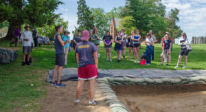 Site Supervisor Anna Shackelford describes the clay borrow pit excavations to the field school students.