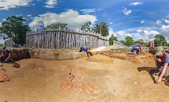 The Jamestown Rediscovery team prepares the area of the 1607 burial ground where this year's burial excavations will take place. The three dark rectangles are the top of the grave shafts. The brick scatter at center may be a robbed hearth from a later building. The brick and cobblestone feature at left is a chimney base for a fort-period building that paralleled the west palisade wall and was approximately 92 feet long.