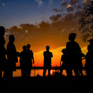 The burials excavation team silhouetted at sunset