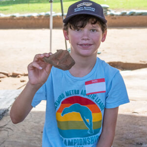 A camper holds a xxx he found while excavating at the cellar site.