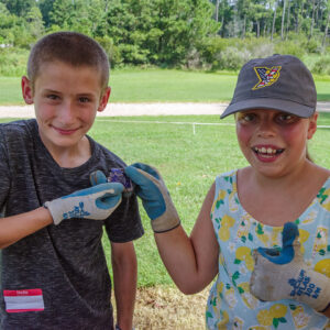 Two campers hold (mending ceramic sherds) they found while screening at the cellar excavations.