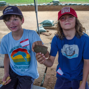 Two campers hold a xxx they found while troweling at the cellar site.