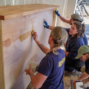 The archaeological team uses linseed oil to finish the ticketing desk.