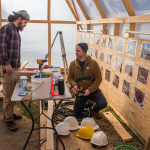 Archaeological Field Technician Josh Barber and Staff Archaeologist Gabriel Brown prepare the repurposed burial structure for excavations adjacent to the ticketing tent.