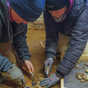 Staff Archaeologist Caitlin Delmas and Archaeological Field Technician Ren Willis excavate plaster found in the Church Tower excavations.