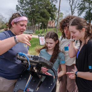 Archaeological Field Technician Hannah Barch explains how ground-penetrating radar works to some visitors.