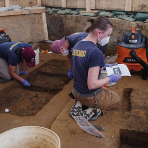 Staff Archaeologist Natalie Reid examines a printout of the ground-penetrating radar (GPR) results to use as a guide during her burial excavations.