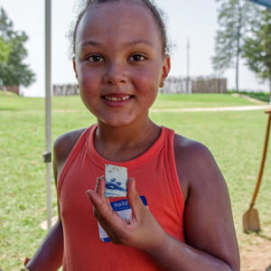 A camper shares a sherd of Chinese porcelain that she found at the borrow pit excavations.