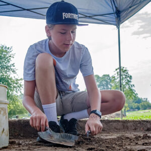 A camper digging in one of the squares just south of the Archaearium.