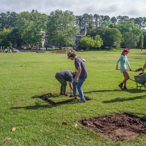 Field school students and staff remove the initial modern layer of soil in new squares outside the Dale House.