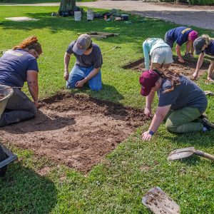 Field school students and staff excavate outside the Dale House.
