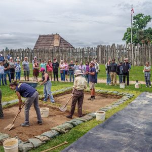 Archaeological Field Technician Josh Barber explains the cellar excavations to visitors.