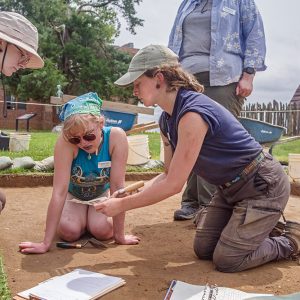 Staff Archaeologist Ren Willis demonstrates use of the Munsell Soil Color Charts to field school students to identify the color of excavated soil.