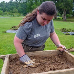 Field school student Sam Gallagher screens for artifacts in soil excavated just outside the Dale House.