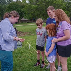 Field school student Molly Morgan shares a partial pipe stem with visitors to the cellar excavations.