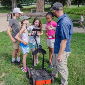 Senior Staff Archaeologist Sean Romo teaches campers how to use the ground-penetrating radar (GPR) machine.