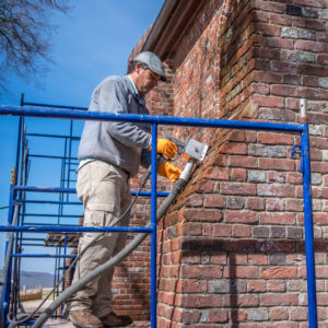 Preservationist on scaffold cleans Memorial Church joints