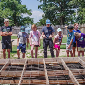 Staff Archaeologist Natalie Reid discusses the Kitchen and Cellar excavations with the campers.