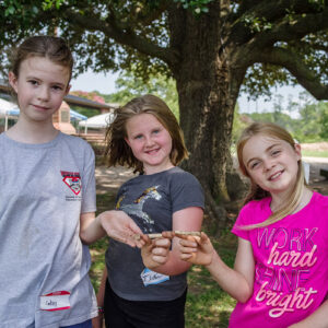 Campers holding a European pipe they found in the excavations south of the Archaearium.