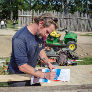 Archaeological Field Technician Gabriel Brown always measures twice before cutting boards for the burial structure.