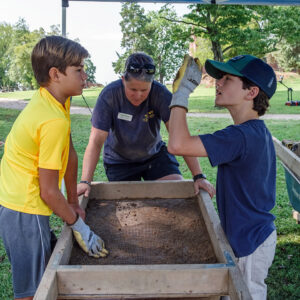 Staff Archaeologist Caitlin Delmas oversees some campers screening for artifacts.