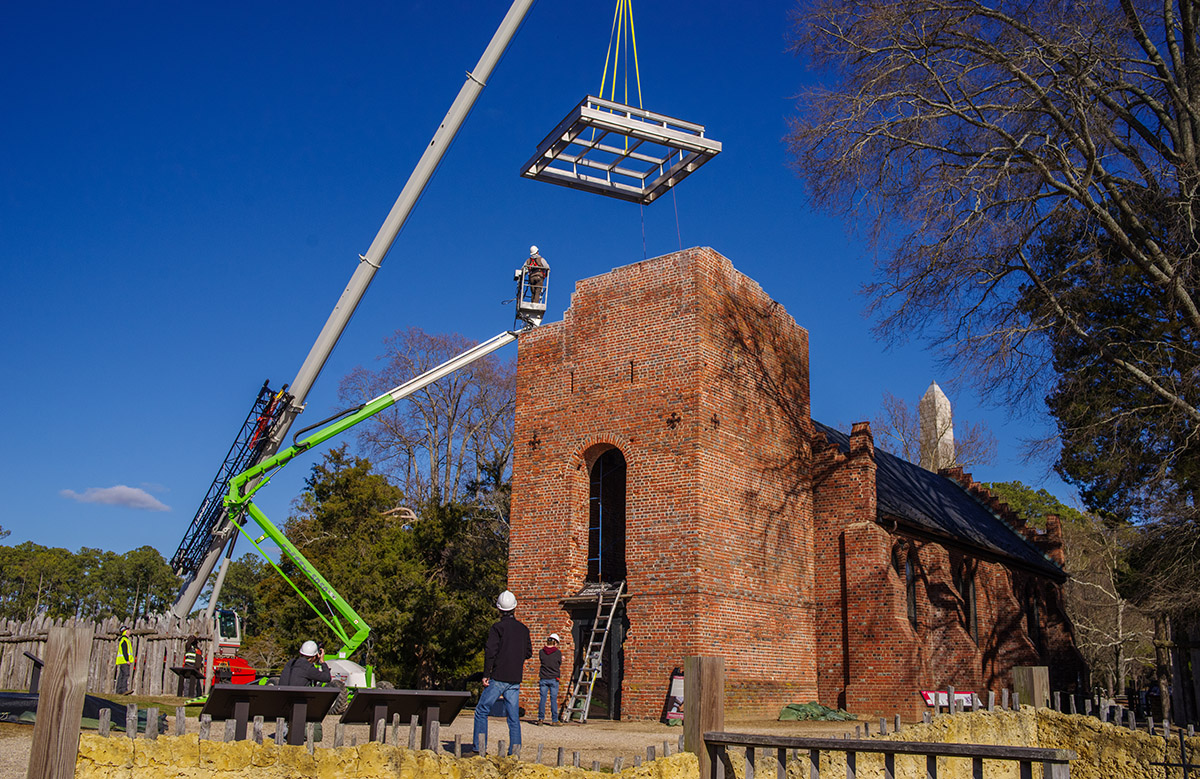 The Church Tower's steel roof infrastructure being carefully guided inside it. Because the roof is slightly below the top of the Tower it will be invisible to those outside it.