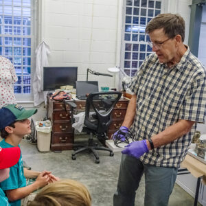 Archaeological Conservator Don Warmke shares a conserved rapier hilt with the Kids Camp attendees.