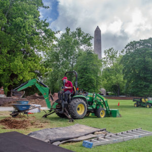 Man operating a backhoe to remove soil