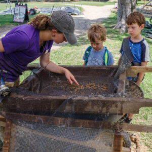 Archaeological Field Technician Ren Willis shares some of her findings during water screening.