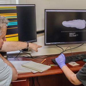 Dr. Chris Wilkins instructs field school student Amelia Fahl in the use of the X-ray machine.