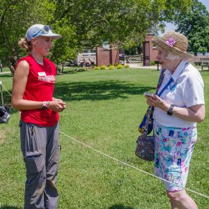 Field school student Natalie White discusses the cellar excavations with a visitor.