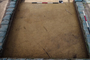 Two burials found just south of the Archaearium are distinguished by their oblong shape and darker soil than that of the surrounding area.