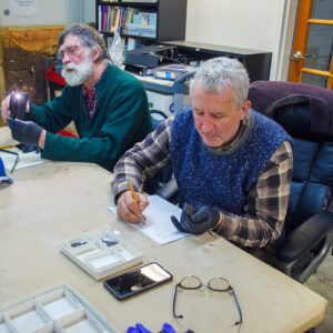 Blacksmiths Shel Browder and Steve Mankowski examine some of the iron artifacts found at Jamestown. Their goal is to reproduce working reproductions of some of these artifacts in the Blacksmith Shop.