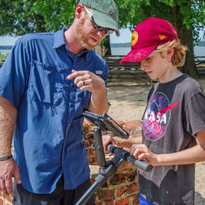 Senior Staff Archaeologist Sean Romo teaches a camper how use the GPR.