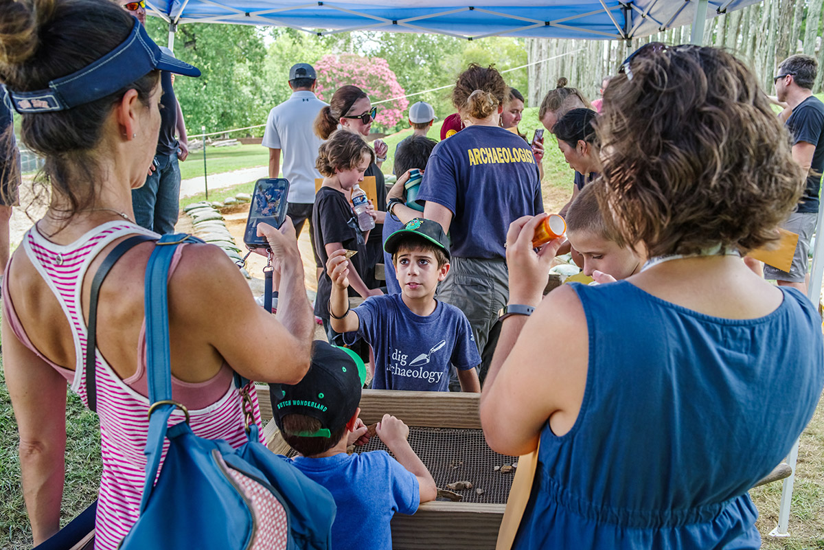 A camper shows a find to relatives on the last day of Kids Camp.