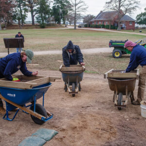 Archaeological Field Technicians Eleanor Robb and Hannah Barch and Staff Archaeologist Caitlin Delmas screen soil excavated from the dig south of the Archaearium.