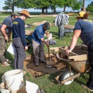 Director of Archaeology Sean Romo discusses the excavations in one of the Smithfield squares with Archaeological Field Technician Eleanor Robb, Staff Archaeologist Natalie Reid and Archaeological Field Technician Hannah Barch.